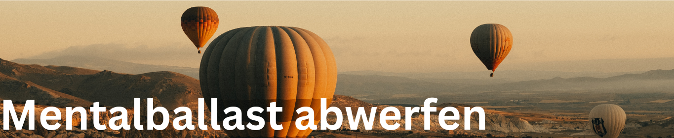 Symbolisiert Psychohygiene. Banner mit Schrift "Mentalballast abwerfen". Heißluftballons in Bergen.